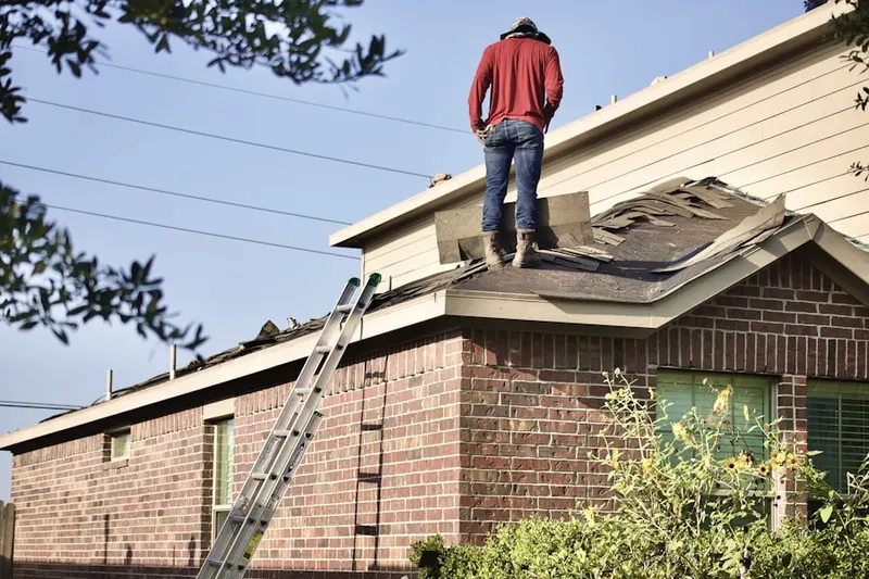 Professional roofer working on a residential roof in Coopersville